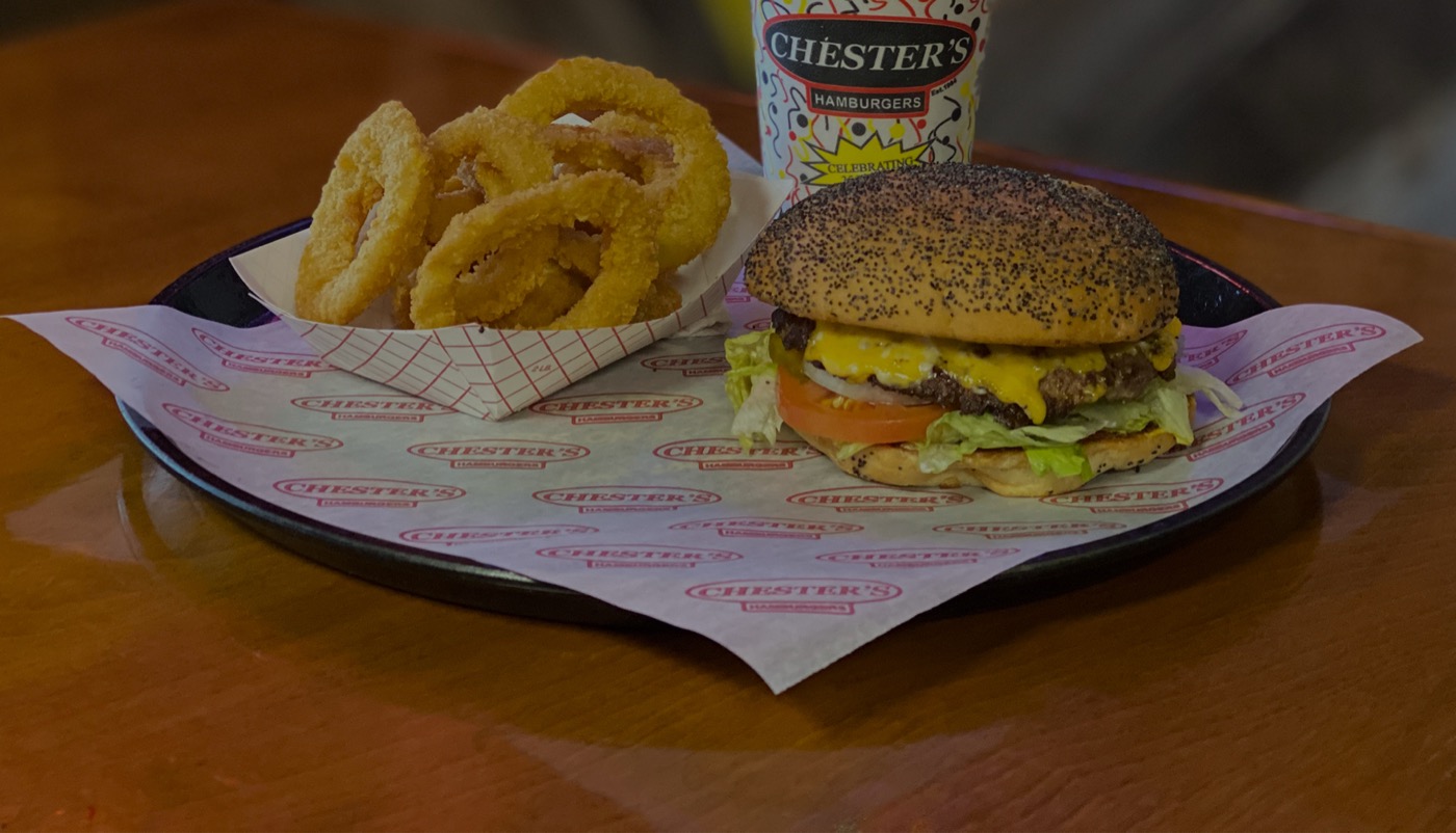 A Chester's burger with onion rings and a Chester's cup, served on a tray